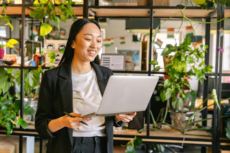 woman working on laptop in office full of plants